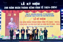 Lãnh đạo tỉnh An Giang và tỉnh Kiên Giang nhận Quyết định xác lập kỷ lục Việt Nam tôn vinh kênh Vĩnh Tế: “Kênh đào thủ công trong khu vực biên giới dài nhất Việt Nam.” (Ảnh: Thanh Sang-TTXVN)