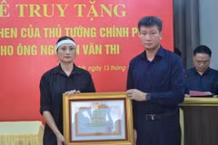 Chủ tịch UBND tỉnh Yên Bái Trần Huy Tuấn trao Bằng khen của Thủ tướng Chính phủ cho đại diện gia đình ông Nguyễn Văn Thi. (Ảnh: TTXVN phát)