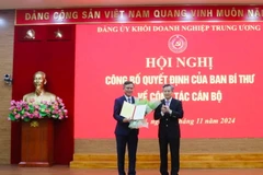 Ông Nguyễn Quang Dương trao quyết định, tặng hoa chúc mừng ông Trần Thắng. (Ảnh: Diệp Trương/TTXVN)