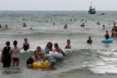 Khách du lịch và người dân đi dạo chơi, tắm biển trên các bãi biển ở Đà Nẵng. (Ảnh: Trần Lê Lâm/TTXVN)