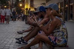 Người dân Cuba sử dụng dịch vụ WiFi công cộng trên một đường phố ở thủ đô La Habana. (Nguồn: AFP/TTXVN)