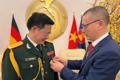 Đại sứ Vũ Quang Minh đeo Kỷ niệm chương Vì sự nghiệp Ngoại giao Việt Nam tặng Đại tá Nguyễn Tuấn Minh, Trưởng phòng Tùy viên Quốc phòng Việt Nam tại Đức. (Ảnh: Phương Hoa/Vietnam+)