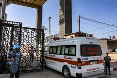 Xe cấp cứu chở người bị thương đi qua cửa khẩu Rafah. (Ảnh: AFP/TTXVN)