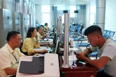 Người dân đến làm thủ tục hành chính. (Ảnh: Quý Trung/TTXVN)