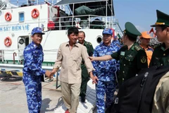 Cơ quan chức năng đón ngư dân bị nạn trên biển trở về. (Ảnh: Đoàn Mạnh Dương/TTXVN)