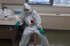 Một nhân viên y tế nghỉ ngơi sau khi kiệt sức vì chăm sóc bệnh nhân nhiễm COVID-19 tại một bệnh viện ở Changwon, Hàn Quốc. (Ảnh: YONHAP/TTXVN)