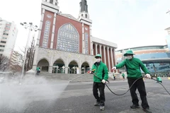 Phun thuốc khử trùng quanh một nhà thờ ở Seoul, Hàn Quốc, nhằm ngăn chặn sự lây lan của virus SARS-CoV-2. (Ảnh: Yonhap/TTXVN)