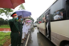 Các cán bộ, chiến sỹ quân y Trung đoàn 58 chào tạm biệt các công dân đã hoàn thành thời gian cách ly trở về địa phương. (Ảnh: Dương Giang/TTXVN)