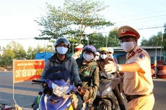 Lực lượng làm nhiệm vụ hướng dẫn người dân vào khai báo y tế cũng như thông tin về lịch trình di chuyển. (Ảnh: Thế Anh/TTXVN)