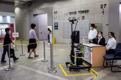 Kiểm tra thân nhiệt phòng lây nhiễm COVID-19 tại tòa nhà ở Hong Kong, Trung Quốc. (Ảnh: AFP/TTXVN)