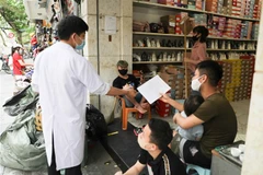 Lực lượng chức năng tuyên truyền, vận động các hộ kinh doanh trên phố Lò Sũ tạm ngừng hoạt động để phòng chống dịch. (Ảnh: Thanh Tùng/TTXVN)