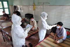 Nhân viên y tế đo thân nhiệt, kiểm tra sức khỏe đối với công nhân phải cách ly. (Ảnh: Dương Chí Tưởng/TTXVN)