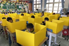 Học sinh Đài Loan dùng tấm plastic để ngăn cách. (Nguồn: NBC News)