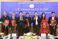 Phó trưởng Ban Tuyên giáo Trung ương Lê Mạnh Hùng và Thứ trưởng Bộ Thông tin và Truyền thông Hoàng Vĩnh Bảo trao giấy phép cho 18 tạp chí thực hiện chuyển đổi, sắp xếp lại theo quy hoạch báo chí. (Ảnh: Minh Quyết/TTXVN)