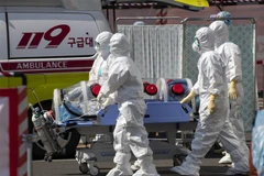 Nhân viên y tế chuyển bệnh nhân nhiễm COVID-19 tới bệnh viện ở Daegu, Hàn Quốc. (Ảnh: THX/TTXVN)