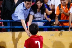 Xuân Trường bịn rịn nắm tay cha mẹ sau trận Việt Nam - Đài Loan tại Hàng Đẫy tối qua. (Ảnh: Minh Chiến/Vietnam+)