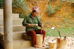 Sau khi cưa gỗ thành từng khúc nhỏ, bà Dìm phụ trách phần đục làm rỗng lõi và bào hoàn thiện. (Ảnh: Huyền Trang/Vietnam+)