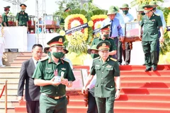 Truy điệu, an táng 19 liệt sỹ là quân tình nguyện, chuyên gia Việt Nam hy sinh tại Lào. (Ảnh: Đức Thọ/TTXVN)