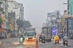 Đường Bạch Đằng (quận Tân Bình) biến thành sông trong mưa. (Ảnh: Hồng Giang/TTXVN)