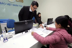 Khách hàng giao dịch tại một chi nhánh bảo hiểm nhân thọ. (Ảnh: Trần Việt/TTXVN)