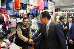 Đại sứ Đặng Minh Khôi hỏi thăm tình hình làm ăn buôn bán của bà con. (Ảnh: Duy Trinh/TTXVN)