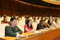 Các đại biểu Quốc hội biểu quyết thông qua Nghị quyết phê chuẩn đề nghị của Chủ tịch nước về danh sách các Phó Chủ tịch và các Ủy viên Hội đồng quốc phòng và an ninh. (Ảnh: Trọng Đức/TTXVN)