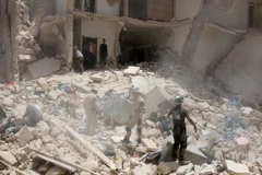 Lực lượng cứu hộ tìm kiếm người mắc kẹt trong đống đổ nát sau cuộc giao tranh ở Aleppo ngày 20/6. (Nguồn: AFP/TTXVN)