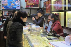 Khách hàng đang giao dịch vàng miếng. (Ảnh: Đức Duy/Vietnam+)