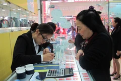Khách hàng đang giao dịch vàng miếng. (Ảnh: Đức Duy/Vietnam+)