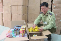 Cán bộ Đội Quản lý thị trường số 15 đang kiểm tra lô bánh kẹo nhập lậu từ Trung Quốc. (Ảnh: Đức Duy/Vietnam+)