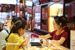 Khách hàng giao dịch vàng tại Hà Nội. (Ảnh: Đức Duy/Vietnam+)