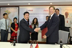 Ông Michael Greene, Giám đốc USAID Việt Nam, và Giám đốc chuỗi cung ứng Coca-Cola Việt Nam, ký biên bản ghi nhớ tại văn phòng của USAID Việt Nam. 