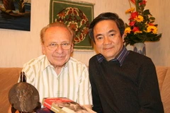 Tác giả cùng nhà báo Kapfenberger tại nhà riêng với cuốn sách và bức phù điêu Hồ Chí Minh. (Ảnh: Thanh Hải/Vietnam+)