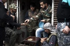 Lực lượng nổi dậy phân phát đạn cho nhau tại quận Karm al-Jabal, thành phố Aleppo ngày 22/10. (Ảnh: AFP/TTXVN)