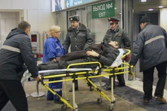 Chuyển một người bị thương trong vụ đánh bom ra khỏi sân bay Domodedovo. (Ảnh: AFP/TTXVN)
