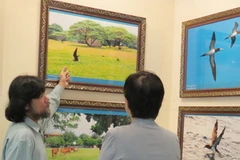 Tác giả Hoàng Chí Hùng (trái) chia sẻ về vẻ đẹp của Trường Sa với khách tham quan. (Nguồn: tuoitre)