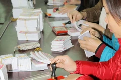 Đóng dấu vé xổ số trước khi phát hành. (Ảnh: Phạm Hậu/TTXVN)