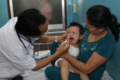 Khám chữa bệnh cho trẻ bị tay, chân, miệng. (Ảnh: Phương Vy/TTXVN)