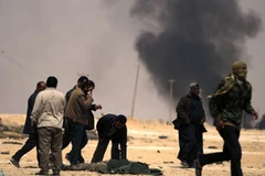 Quân chống đối thu thập xác binh sỹ chính phủ trung thành với lãnh đạo Gaddafi sau khi tiến vào thị trấn Ajdabiya. (Ảnh minh họa. AFP/TTXVN)