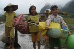 Trẻ em Tân Hóa đi lượm lặt những thứ còn sót lại trong cơn lũ vừa qua. (Ảnh: Nguyễn Đức Thọ/Vietnam+)