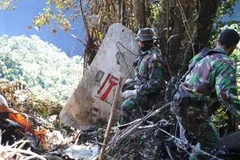 Binh sỹ Indonesia tìm kiếm hành lý và các phần thi thể nạn nhân vụ tai nạn máy bay Sukhoi Superjet 100. (Nguồn: Getty Images)