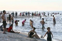 Nắng nóng, người dân đổ ra biển để giải nhiệt. (Ảnh: Hồ Cầu/TTXVN)