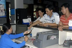 Bán vé tàu cho hành khách. (Ảnh: Hoàng Hải/TTXVN).