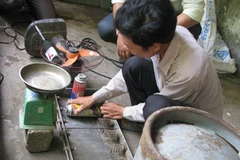 Quyền bị bắt quả tang đang sang chiết gas trái phép. (Nguồn: NLĐ)