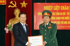 Trung tướng Đào Duy Minh trao tặng Phó Thủ tướng Xổmxavạt Lềnhxavắt bộ sách quý. (Ảnh: Trọng Đức/TTXVN)