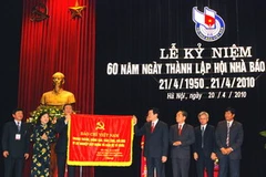 Thường trực Ban Bí thư Trương Tấn Sang trao tặng bức trướng cho Hội Nhà báo Việt Nam. (Ảnh: Huy Hùng/TTXVN). 