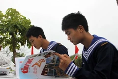 Chiến sỹ đảo Bạch Long Vĩ say sưa đọc báo. (Ảnh: Tuấn Anh/Vietnam+)