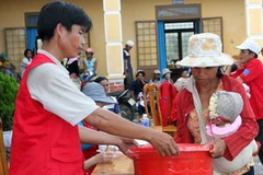 Phát gạo cứu trợ cho đồng bào vùng lũ. (Ảnh: Trần Lê Lâm/TTXVN).