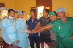 Các thuyền viên tàu QNg95490 TS chúc mừng và cảm ơn kíp quân y sau ca mổ. (Ảnh: Cao Dân/Vietnam+)