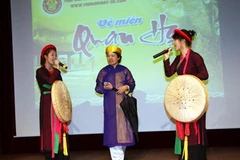 Anh Hoàng Lê cùng hai con gái Ngọc Trang và Lan Anh biểu diễn một bài quan họ. (Ảnh: Văn Long-Thanh Hải/Vietnam+)